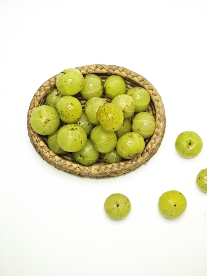 journey Indian gooseberries in a woven basket on a white background, shot in Kolkata, India.